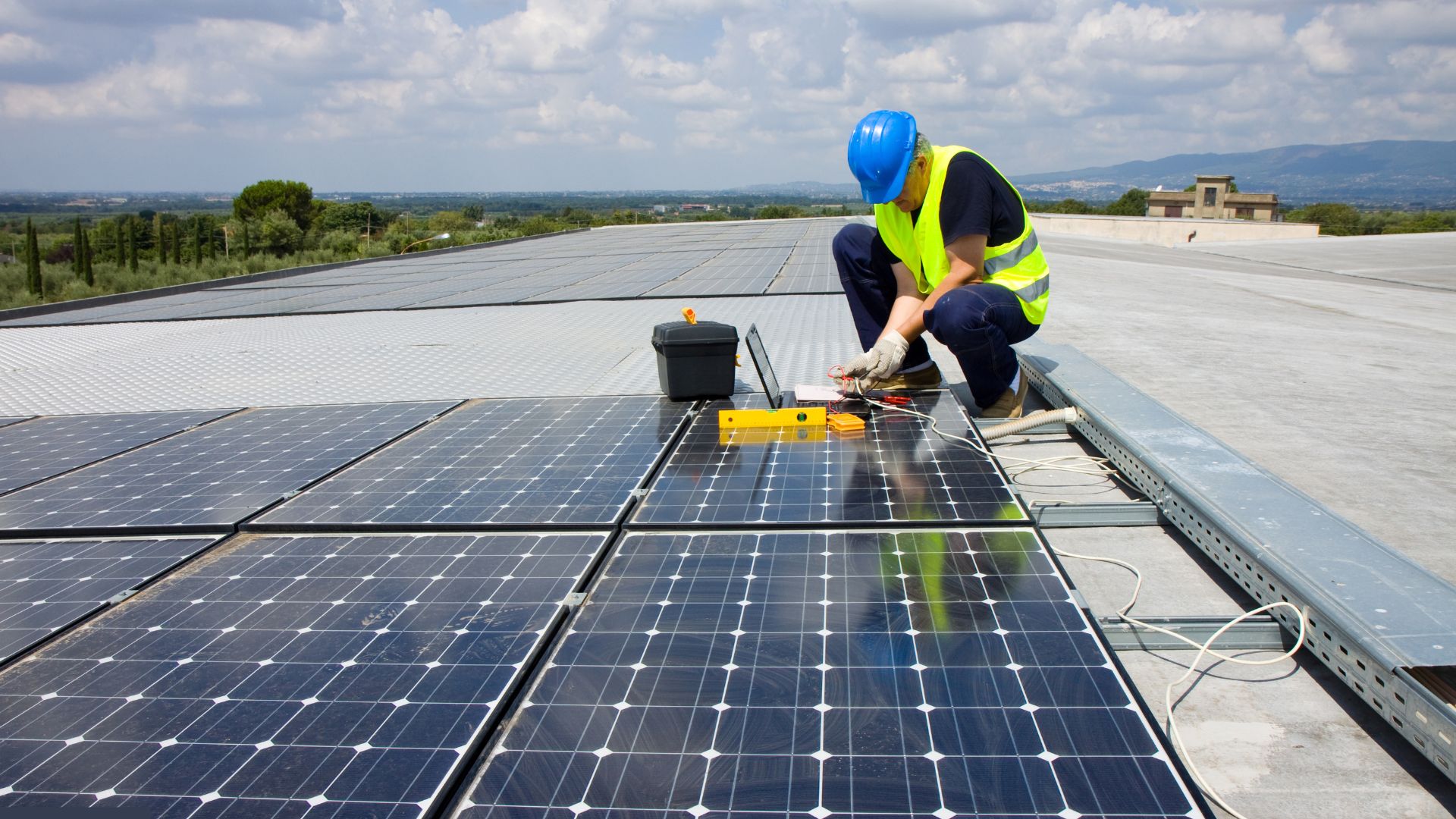 an engineer installing solar panels on a flat rooftop