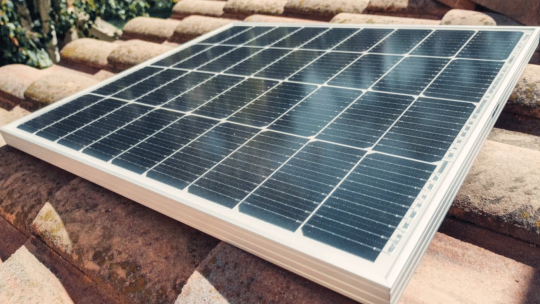 Single solar panel resting on a tiled roof surface during installation.