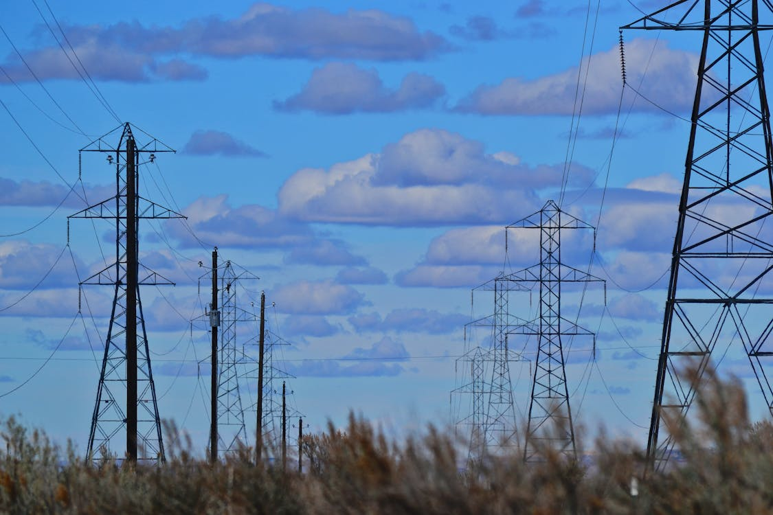 Electric towers lined up under the blue calm sky, essential for selling electricity back to the grid.