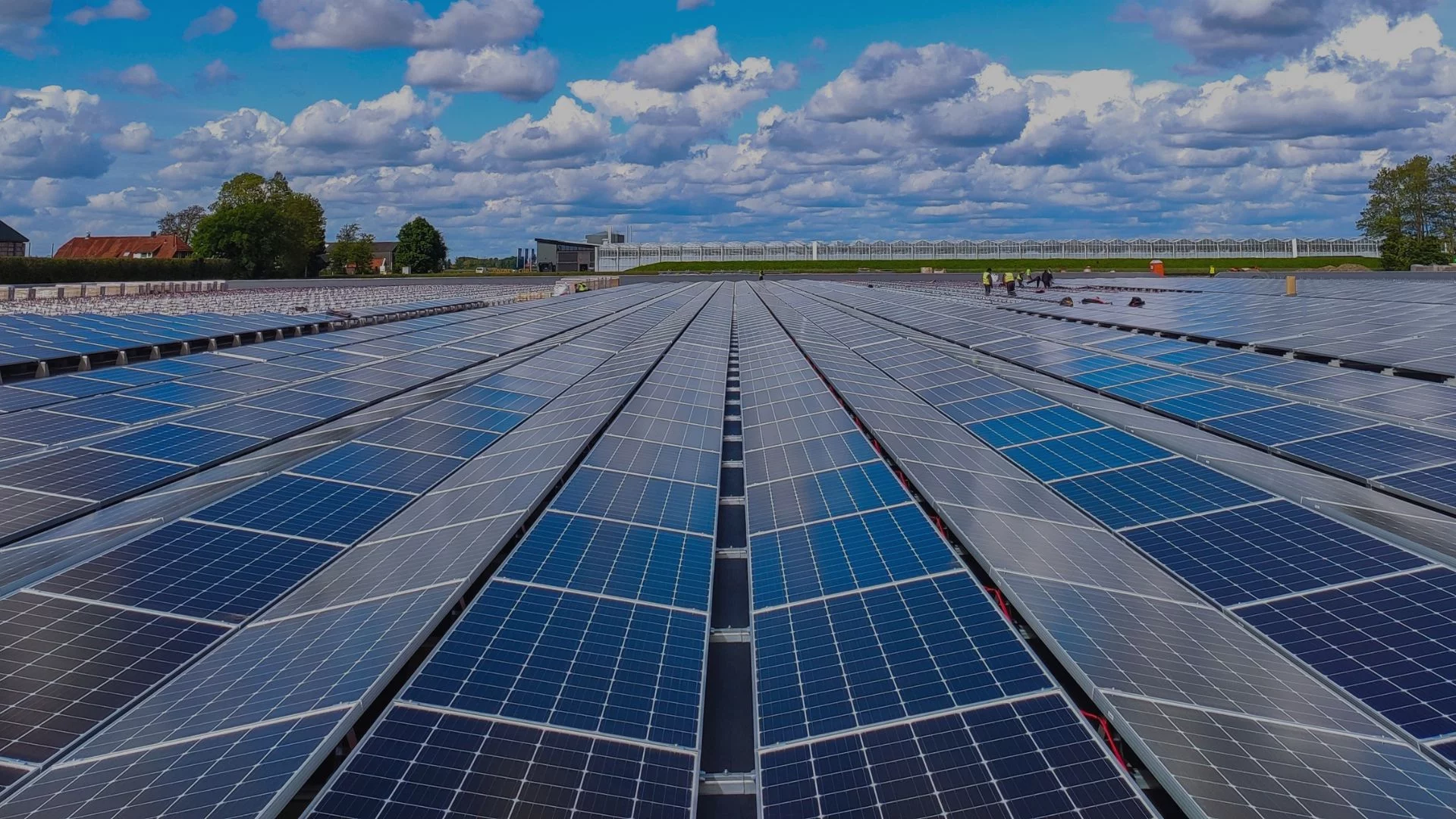 Domestic solar system at maximum size, featuring solar panels on a roof with a bright blue sky and scattered clouds above