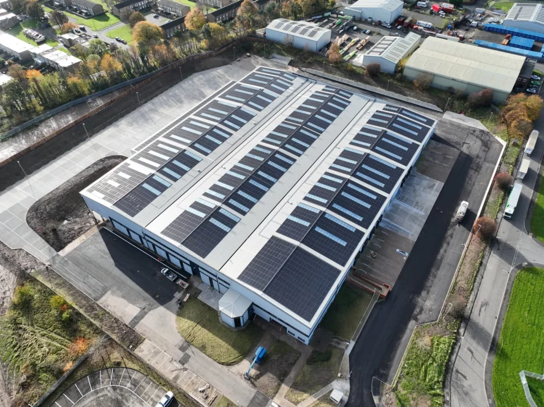 Aerial view of a large industrial warehouse fitted with a rooftop solar PV system.