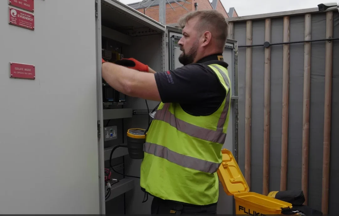 EvoEnergy technician performing maintenance work on a solar panel installation electrical cabinet, showcasing professional upkeep services.