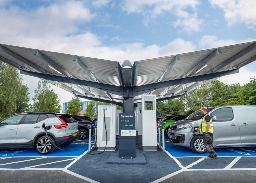 Covered EV HyperHub charging station featuring rapid and ultra-rapid chargers, with a Volvo SUV and a commercial van plugged in, in HyperHubs