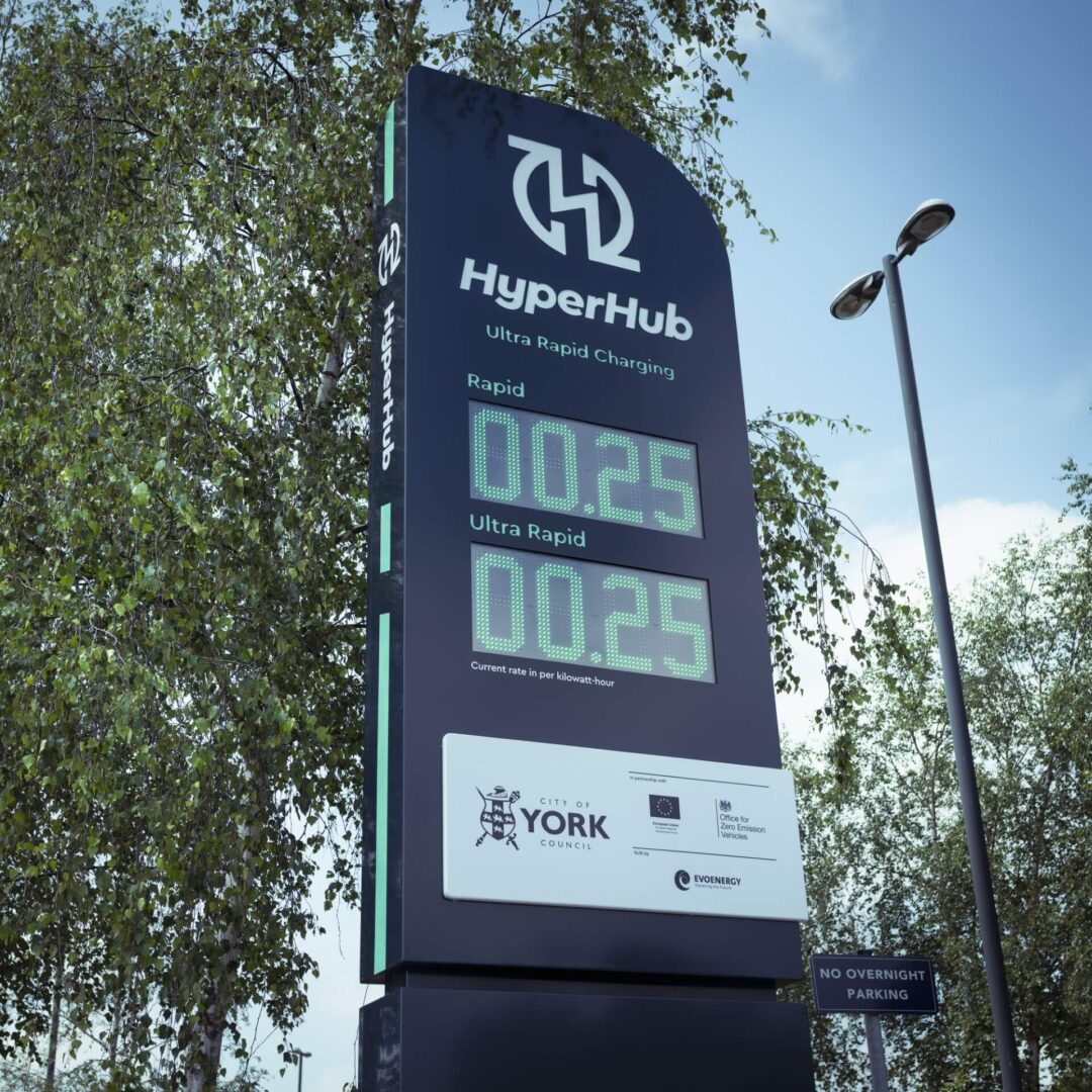 Close-up of the HyperHub Ultra Rapid Charging station sign displaying current kilowatt-hour rates and logos for City of York Council in HyperHubs