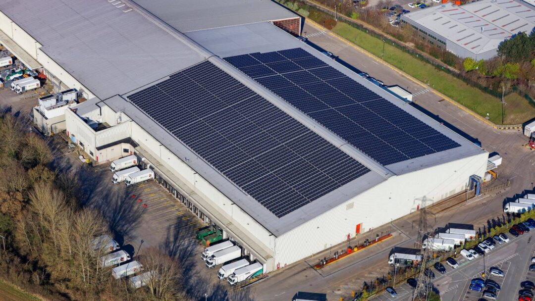 Solar panels atop a building alongside parked lorries