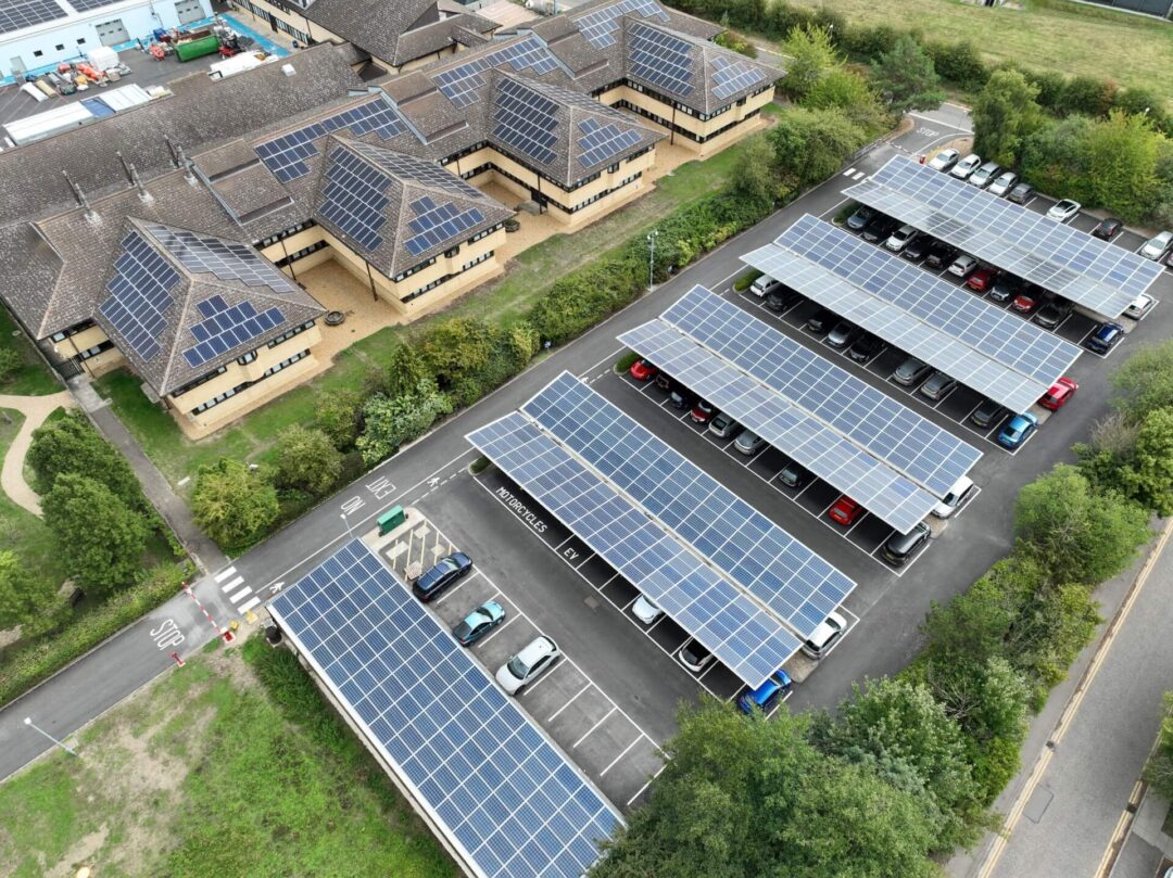 Solar-covered carport adjacent to a research lab with rooftop solar panels