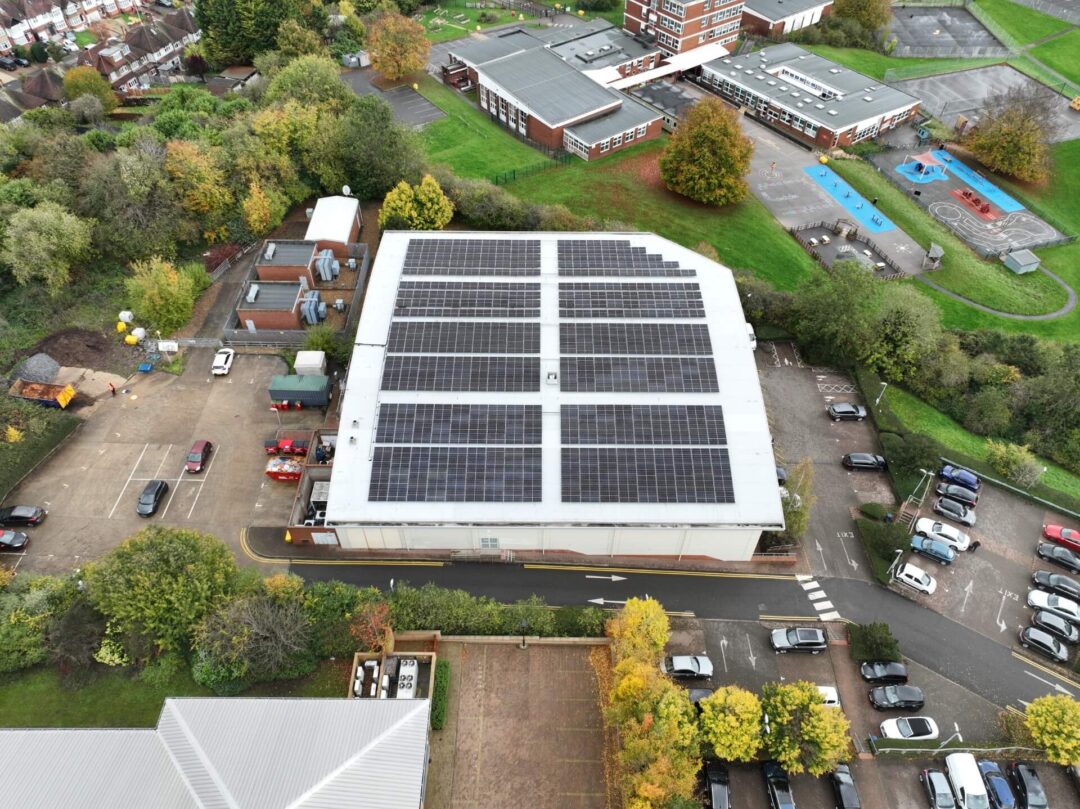 Curved-roof gymnasium empowered by sleek solar panel installation.