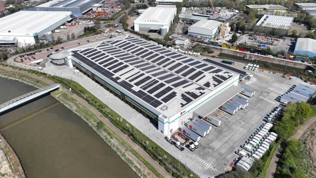 Aerial view of a DPD distribution centre with extensive rooftop solar panel installation, supporting low-carbon logistics and renewable energy use in an urban industrial area in DPD Docklands.