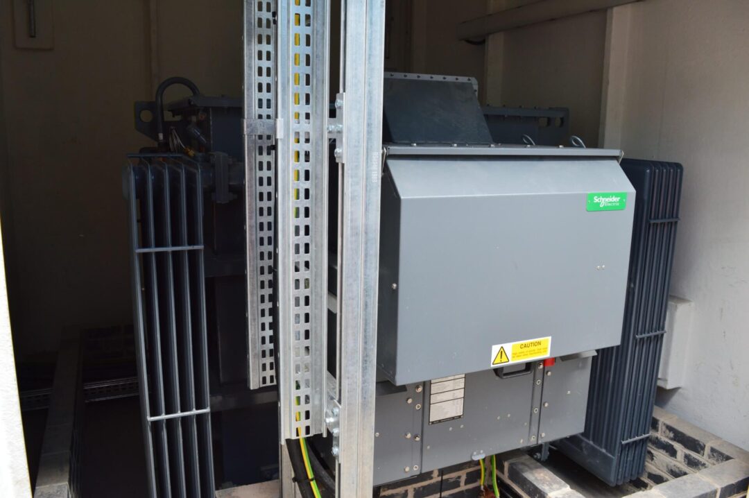 Schneider Electric transformer unit installed indoors with metal support framing and visible electrical cabling in John A Stephen