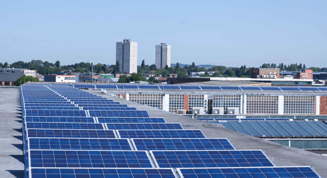 Large rooftop solar panel installation on a commercial building in a business district.