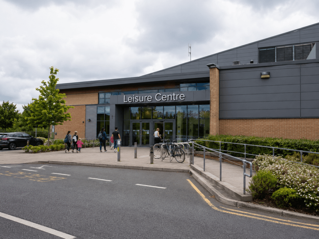 Leisure centre entrance with visitors, bike racks, and modern building exterior for solar energy planning.